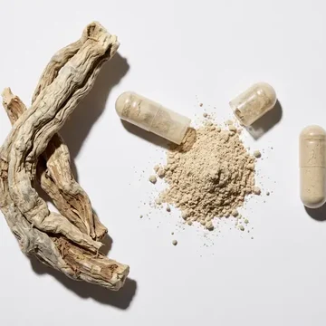 Raiz de ashwagandha ao lado do pó e de cápsulas