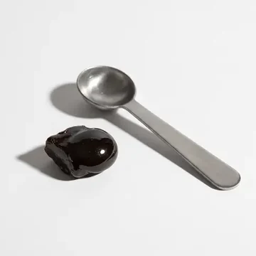 Resina de shilajit purificada ao lado de cápsulas